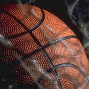 May include: Close-up of an orange basketball with black lines, showing the textured surface of the ball.