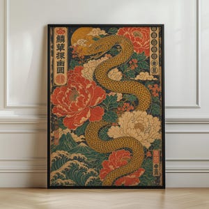 Op de afbeelding: Een rechthoekige wandkunstprint in een zwarte lijst met een gouden slang die door grote rode en crèmekleurige pioenrozen kronkelt. De achtergrond bevat gestileerde golven, bergen, wolken en Japanse tekstkarakters in verticale kolommen.