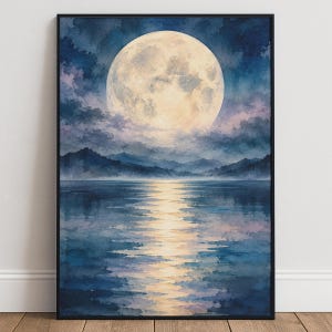 Puede incluir: Una lámina de arte enmarcada que muestra una gran luna llena luminosa en un cielo nocturno oscuro y nublado sobre una masa de agua tranquila. La luz de la luna crea un reflejo dorado brillante en la superficie azul, con montañas oscuras.