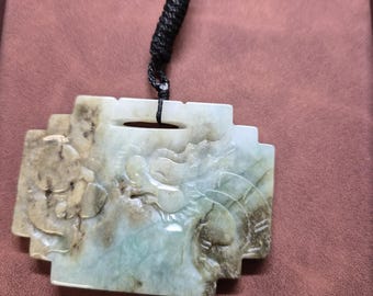 Multi colored jade pendant with dragon carving on black rope.