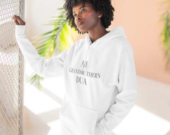 May include: A white long-sleeve hooded sweatshirt featuring a front kangaroo pocket and the black text MY GRANDMOTHER'S DUA printed in a serif font across the chest. The garment has a drawstring hood and ribbed cuffs at the wrists.