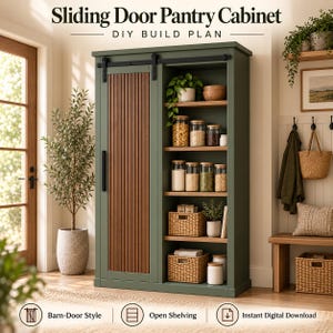 Puede incluir: Un armario despensa alto de color verde oscuro con una puerta corredera estilo granero con listones de madera verticales y una sección de estantes abiertos a la derecha. La unidad incluye varios estantes llenos de frascos de vidrio y cestas tejidas.