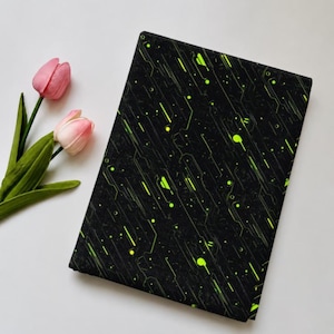 May include: A rectangular piece of black fabric featuring a vibrant neon green circuit board pattern with thin lines, dots, and geometric shapes arranged in a diagonal orientation across the surface, paired with two pink tulip flowers.