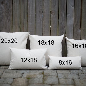 May include: Five white cotton pillow covers of different sizes. The pillow covers are arranged in a row from largest to smallest. The sizes are labeled 20x20, 18x18, 16x16, 12x18, and 8x16.