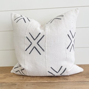 May include: White throw pillow with a black geometric pattern. The pattern is made up of repeating X shapes.