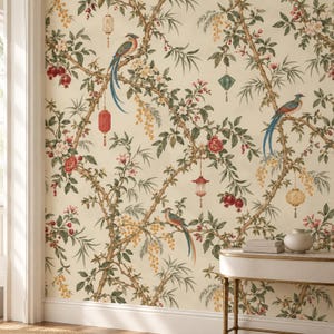 May include: Wallpaper featuring a cream background with a repeating pattern of brown branches, green leaves, red pomegranates, white and red flowers, yellow blossoms, colorful birds with long tail feathers, and hanging decorative lanterns.