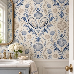 May include: Wallpaper featuring a repeating pattern of blue and beige seashells, oyster shells, and pearl accents on a cream background. The design includes intricate blue scrolling foliage elements arranged in a symmetrical damask-like layout.