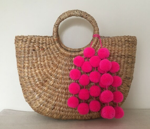 straw handbag with pom poms