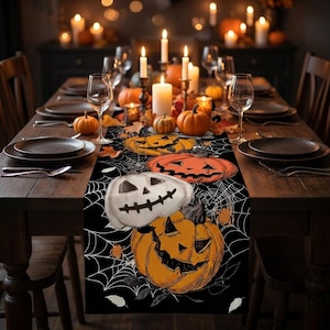 Peut inclure: Un chemin de table noir orné d'un motif de toile d'araignée blanche et de plusieurs citrouilles d'Halloween orange et blanches. Le design présente divers visages de citrouilles sculptées aux yeux triangulaires et bouches dentelées.