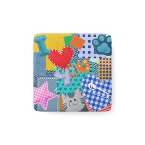 Puede incluir: Un posavasos cuadrado con un diseño de patchwork colorido y diversas texturas de tela. Muestra un corazón rojo, una huella azul, una estrella de cuadros rosa, una cara de gato gris y el texto I LOVE YOU en letras cosidas con un imperdible.