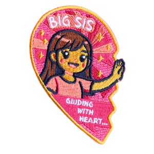 May include: A heart-shaped embroidered patch with a pink background featuring a cartoon character with brown hair and a pink shirt. The text BIG SIS is at the top and GUIDING WITH HEART is at the bottom. The design includes yellow stars and a yellow border.