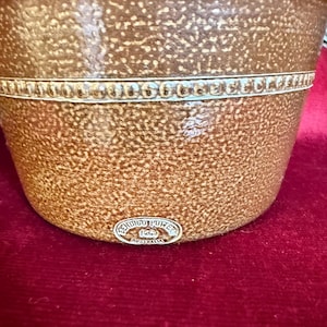 May include: A brown glazed ceramic crock with a textured surface and a horizontal decorative band featuring a repeating dot pattern. An oval sticker at the base displays the text Bendigo Pottery Australia with a central logo icon.