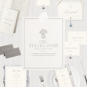May include: A wedding stationery collection featuring off-white paper cards with gray text and floral illustrations. Items include a menu, table number, reserved sign, guest book card, and bar sign, all displaying the text The Heirloom Collection.