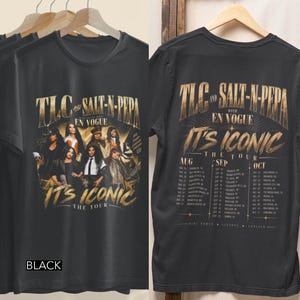 Op de afbeelding: Een zwart t-shirt met een grafische print van TLC, Salt-N-Pepa en En Vogue met de tekst "TLC AND SALT-N-PEPA WITH EN VOGUE IT'S ICONIC THE TOUR". De achterkant toont het tourschema met data en steden onder dezelfde tourtitel.