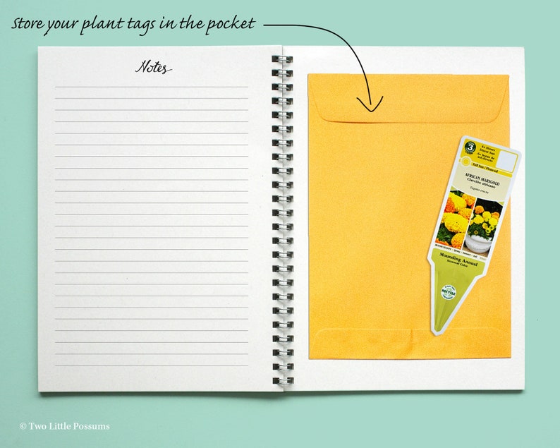 May include: A white notebook with a yellow envelope pocket on the right side. The text "store your plant tags in the pocket" is written at the top of the page. The text "Notes" is written at the top of the left page. A plant tag with a picture of yellow flowers is in the pocket.