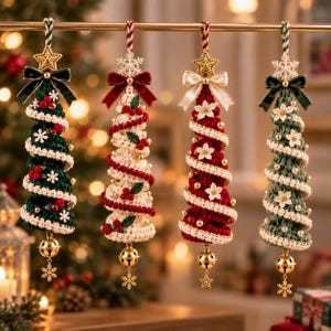 May include: Four hanging crochet Christmas tree ornaments in dark green, cream, red, and sage green. Each tree features a spiral design, a velvet bow, a star or snowflake topper, small pearl beads, and a gold jingle bell with a snowflake charm at the base.