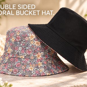Puede incluir: Un sombrero de pescador floral de doble cara con una base gris y un estampado floral multicolor en un lado y una tela negra sólida en el reverso. El texto DOUBLE SIDED FLORAL BUCKET HAT está impreso en blanco en la esquina superior.