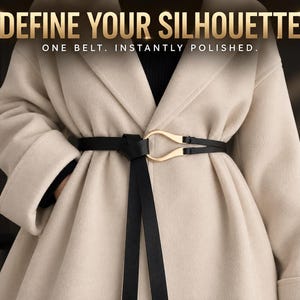 May include: A black belt with a gold-toned metal buckle worn over a beige coat. The text "DEFINE YOUR SILHOUETTE" and "ONE BELT. INSTANTLY POLISHED." is displayed at the top of the image in a bold, sans-serif font.