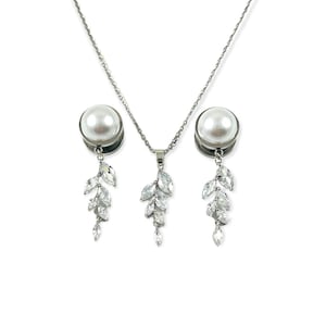 May include: A silver necklace and earrings set with a pearl pendant and dangling crystal accents. The pendant and earrings feature a leaf design with clear crystals.
