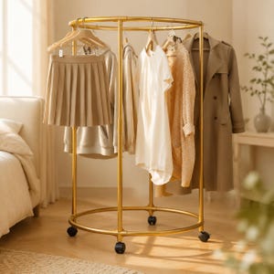 Puede incluir: Un perchero circular de metal dorado con ruedas, que sostiene una falda plisada beige, una sudadera con capucha clara, una camiseta blanca de manga corta, un cárdigan de punto beige y una gabardina color canela en perchas de madera.