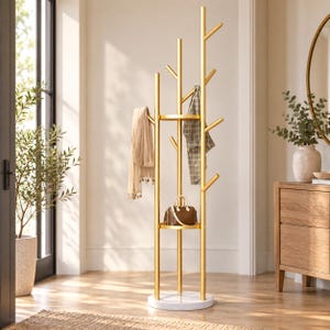 Puede incluir: Un perchero de metal dorado con una estructura en forma de árbol que cuenta con múltiples ramas para colgar objetos. Incluye dos estantes circulares, una base de estilo mármol blanco, una bufanda beige, una chaqueta a cuadros y un bolso marrón pequeño.