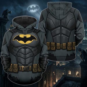 Könnte beinhalten: Ein dunkelgrauer Kapuzenpullover mit einem aufgedruckten Batman-Kostümdesign. Die Vorderseite zeigt ein gelb-schwarzes Fledermaus-Emblem auf der Brust und einen braunen Gürtel an der Taille. Die Rückseite zeigt ein passendes graues Rüstungsmuster.