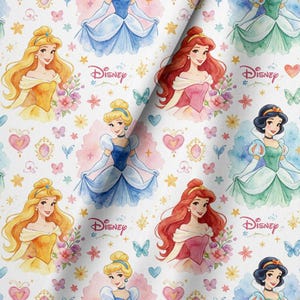 May include: A white fabric featuring a repeating pattern of Disney princesses including Cinderella, Belle, Ariel, and Snow White. The design includes watercolor-style accents, small butterflies, hearts, flowers, and stars, with the Disney logo printed in pink.