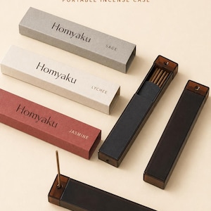 May include: Three rectangular cardboard boxes labeled Homyaku in gray, cream, and red, with scents Sage, Lychee, and Jasmine. Two dark brown translucent plastic cases are shown, one open revealing incense sticks and one closed, plus a third case.