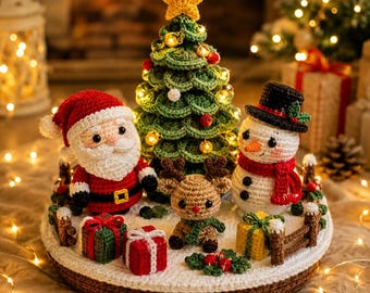 May include: A crochet Christmas display featuring a central green tree topped with a yellow star, flanked by a Santa Claus figure, a brown reindeer, and a snowman wearing a black hat and red scarf, all arranged on a white base with small gifts.