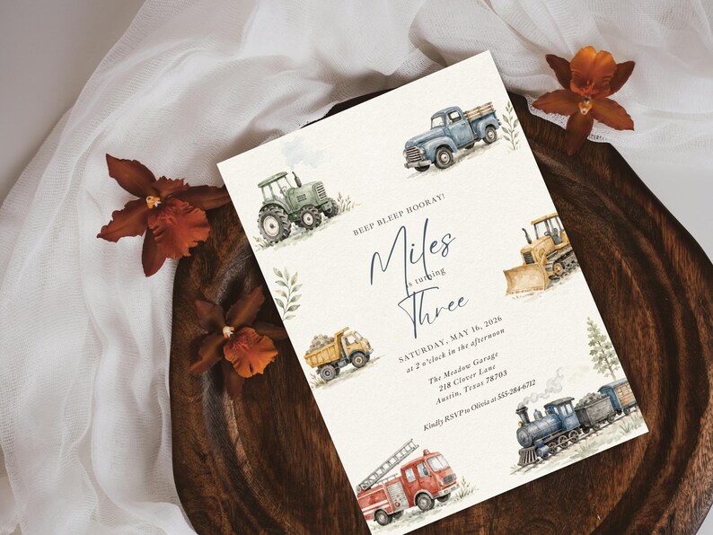 May include: A rectangular birthday invitation card featuring watercolor illustrations of a blue pickup truck, green tractor, yellow bulldozer, dump truck, red fire engine, and a steam train. The text reads BEEP BLEEP HOORAY! Miles is turning THREE, SATURDAY, MAY 16, 2026, at 2 o'clock in the afternoon, The Meadow Garage, 218 Clover Lane, Austin, Texas 78703, Kindly RSVP to Olivia at 555-284-6712.