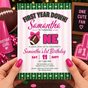 Puede incluir: Una tarjeta de invitación de cumpleaños rectangular con un fondo de rayas rosas y blancas y líneas de campo de fútbol americano verdes en la parte superior e inferior. El texto dice: FIRST YEAR DOWN! Samantha IS TURNING ONE, PLEASE JOIN US TO CELEBRATE Samantha's 1st Birthday.