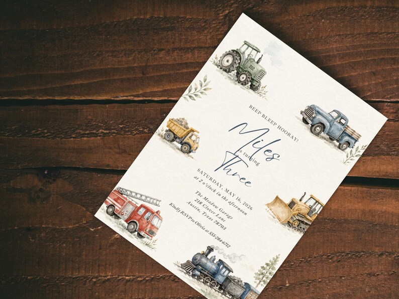 May include: A white rectangular invitation card featuring watercolor illustrations of a green tractor, yellow dump truck, blue pickup truck, red fire engine, yellow bulldozer, and a blue steam train, with text reading BEEP BLEEP HOORAY! Miles is turning Three.