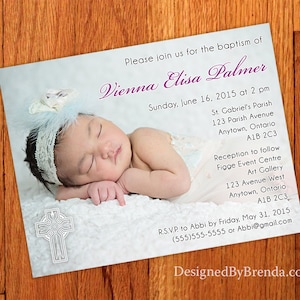 May include: A baptism invitation with a photo of a baby girl sleeping on a white blanket. The invitation is light blue with white text and a white cross. The text reads "Please join us for the baptism of Vienna Elisa Palmer Sunday, June 16, 2015 at 2 pm St. Gabriel's Parish 123 Parish Avenue Anytown, Ontario A1B 2C3 Reception to follow Figge Event Centre Art Gallery 123 Avenue West Anytown, Ontario A1B 2C3 R.S.V.P. to Abbi by Friday, May 31, 2015 (555)555-5555 or Abbi@gmail.com DesignedByBrenda.com"