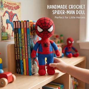 Könnte beinhalten: Eine handgefertigte Spider-Man-Häkelpuppe mit einem Körper aus rotem und blauem Garn, einem schwarzen Spinnenemblem auf der Brust, großen weißen Augen mit schwarzer Umrandung und einem auf den roten Kopf gestickten Netzmuster, stehend neben Comics.