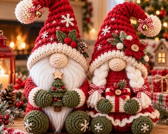May include: Two crocheted Christmas gnomes sitting side by side. The left gnome wears a red hat with white snowflakes, a pom-pom, and a plaid bow, holding a small green tree. The right gnome has white braided hair and holds a gift.