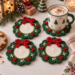 Puede incluir: Tres posavasos redondos de ganchillo con un centro color crema rodeado por un borde de corona verde oscuro, decorados con pequeñas flores blancas, bayas rojas y un lazo rojo prominente en la parte superior, sobre una superficie clara.
