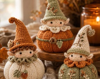 Puede incluir: Tres figuras de ganchillo con forma de calabaza, sombreros puntiagudos y rostros de elfo. La figura de la izquierda es crema con sombrero naranja, la central es naranja con sombrero verde y la de la derecha es verde con sombrero color crema.
