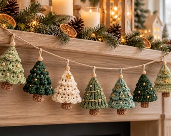 May include: A festive garland featuring seven crocheted Christmas tree ornaments in shades of sage green, dark forest green, and cream. Each tree is suspended from a natural jute twine string with a small wooden bead and brown trunk.