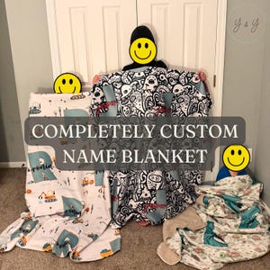 May include: Three custom name blankets featuring distinct patterns: one with construction vehicles, one with a black and white doodle design, and one with a turtle print. The text "COMPLETELY CUSTOM NAME BLANKET" is overlaid on the image.