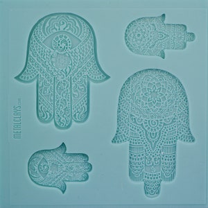 May include: A silicone mold with four detailed hamsa hand designs. The hamsa hands are intricately patterned with a variety of swirls and lines. The mold is light blue and has the text "METALCLAYS.com" on the side.