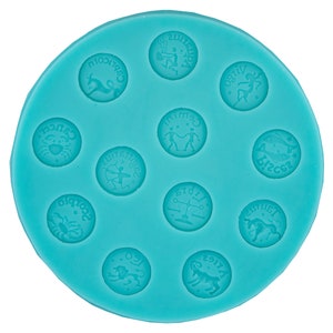 Op de afbeelding: Een turquoise blauwe siliconen mal met 12 ronde indrukken, elk met een ander sterrenbeeld. De tekens zijn: Waterman, Steenbok, Kreeft, Boogschutter, Schorpioen, Weegschaal, Stier, Ram, Maagd, Tweelingen, Vissen en Leeuw.
