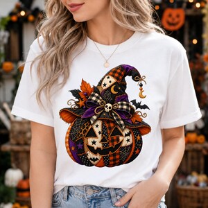 May include: A white short-sleeved t-shirt featuring a graphic of a jack-o'-lantern wearing a patchwork witch hat. The pumpkin and hat are decorated with orange, black, and purple patterns, including plaid, stars, spiderwebs, and a small skull.