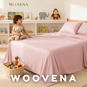 May include: A light pink bed sheet set with a subtle vertical striped pattern, featuring two matching pillows on a bed. The bedding is displayed in a room with a white bookshelf containing children's books and toys, including a plush monkey and elephant.