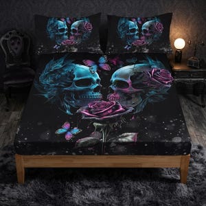 May include: A black bed sheet set featuring a graphic print of two skulls facing each other, surrounded by vibrant blue and purple roses and butterflies. The design includes a large central rose and matching pillowcases with a similar skull motif.