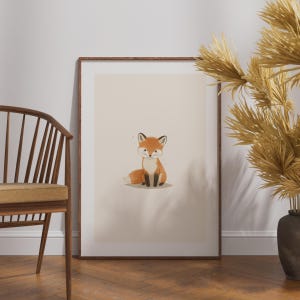 May include: A rectangular wall art print in a dark wood frame featuring a centered illustration of a small orange and white fox with black-tipped ears and paws, set against a solid light beige background with subtle speckles.