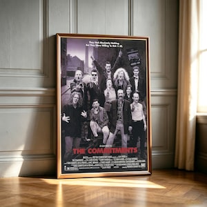 Könnte beinhalten: Ein gerahmtes schwarz-weiß Filmplakat für The Commitments mit einer Gruppe von Menschen, die auf einer Straße posieren. Der Text lautet: They Had Absolutely Nothing, But They Were Willing To Risk It All. The Commitments ist in Rot gedruckt.
