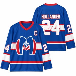 May include: A blue long-sleeve hockey jersey with red and white accents. The front features a large M logo with a fleur-de-lis and the text ESTO 1909, plus a C patch. The back displays the name HOLLANDER and the number 24 in white lettering.