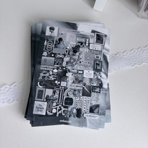 May include: A rectangular sticker sheet featuring a collage of black and white graphics, including small photographs, musical notes, stars, hearts, and various text snippets like "The Romantic Choice," "Be forever mine," and "enhacafe" at the bottom.