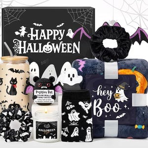 Puede incluir: Un set de regalo de Halloween que incluye una caja negra con el texto Happy Halloween, un vaso con estampados de gatos y murciélagos, un murciélago de ganchillo con etiqueta Positive Bat, una vela, calcetines con fantasmas y una manta con etiqueta hey Boo.