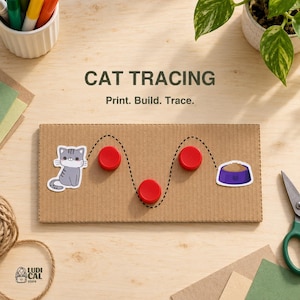 Può includere: Un pezzo rettangolare di cartone ondulato con un percorso a tratti neri stampato, un'illustrazione di un gatto grigio, un'illustrazione di una ciotola per cibo viola e tre tappi di plastica rossi circolari lungo il percorso con il testo CAT TRACING Print. Build. Trace.